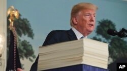 FILE - President Donald Trump speaks in the Diplomatic Room of the White House in Washington, March 23, 2018, about the $1.3 trillion spending bill. 