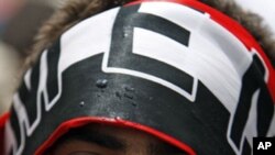 An anti-government protester wraps a Yemeni flag around his mouth during a demonstration to demand the ouster of Yemen's President Ali Abdullah Saleh in Sanaa, May 23, 2011