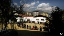 FILE- In this March 24, 2008 file photo, Bhutanese people queue up to cast their votes outside a polling station, in Thimphu, Bhutan.Bhutan’s COVID-19 vaccination drive was fast from the start. As other countries rolled out their vaccination campaigns…