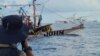 Sebuah kapal Penjaga Pantai China, latar belakang, melewati perahu aktivis dan sukarelawan dari koalisi non-pemerintah bernama Atin Ito di Laut Cina Selatan pada Kamis, 16 Mei 2024. (Foto: via AP)