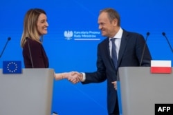 European Parliament President Roberta Metsola and Polish Prime Minister Donald Tusk shake hands at the end of a joint press conference in Warsaw, Poland, on Feb. 15, 2024.