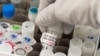 Seorang peneliti mengangkat botol vaksin Covid-19 di laboratorium Novavax di Gaithersburg, Maryland, salah satu laboratorium yang mengembangkan vaksin untuk virus corona. (Foto: AFP)
