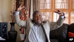 Thamsanqa Jantjie gestures at his home during an interview with The Associated Press in Johannesburg, South Africa, Dec. 12, 2013.