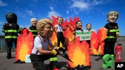 A man wearing a Trump mask, center, is joined by other 'world leaders' during a protest ahead of the G-7 summit in Biarritz, France, Aug. 23, 2019. 