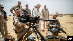 FILE - German defense minister Ursula von der Leyen, center, speaks with German soldiers stationed as part of the Mission ASIFU-MINUSMA at Camp Castor near Gao, Mali, April 5, 2016.