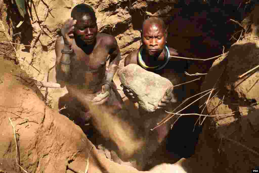 Two artisanal miners dig a pit in a dry riverbed in Karamoja, Uganda, March 2, 2014. (Hilary Heuler for VOA)