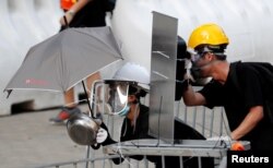 FILE - Protesters use makeshift protective gear to avoid tear gas during the city-wide strike to call for democratic reforms outside Central Government Complex in Hong Kong, Aug. 5, 2019.