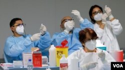 Trabajadores de la salud preparan dosis de la vacuna de Pfizer/BioNTech en un centro de inmunización en Nápoles, Italia, el 8 de enero de 2021.