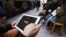 A man tries to get connected to the YouTube web site with his tablet at a cafe in Istanbul, March 27, 2014.