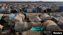 Residents walk past tents at the Bab Al-Salam refugee camp in Azaz, near the Syrian-Turkish border, Nov. 19, 2014.