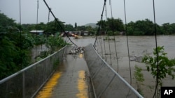 Un puente peatonal colapsó debido a las inundaciones provocadas por las lluvias provocadas por la tormenta tropical Sara en San Pedro Sula, Honduras, el sábado 16 de noviembre de 2024. (Foto AP/Moises Castillo)