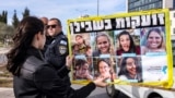 Uma mulher segura um cartaz, enquanto os familiares e apoiantes dos israelitas mantidos como reféns em Gaza se reúnem para um protesto que apela a um acordo de cessar-fogo para garantir a libertação dos reféns, frente ao gabinete do primeiro-ministro em Jerusalém