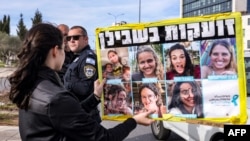 Uma mulher segura um cartaz, enquanto os familiares e apoiantes dos israelitas mantidos como reféns em Gaza se reúnem para um protesto que apela a um acordo de cessar-fogo para garantir a libertação dos reféns, frente ao gabinete do primeiro-ministro em Jerusalém