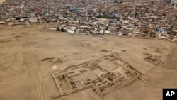 FILE - Homes in the Lurin district stand near the pre-Columbian archeological site Pachacamac in Lima, Peru, Oct. 5, 2017.