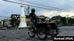 Becak motor melintas di Tugu Yogya yang mulai ramai di tengah pandemi corona. (Foto: VOA/ Nurhadi)