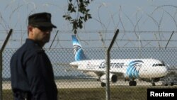 Polisi berjaga di Bandar Udara Larnaka dekat pesawat Egyptair A320 yang dibajak (29/3). (Reuters/Yiannis Kourtoglou)