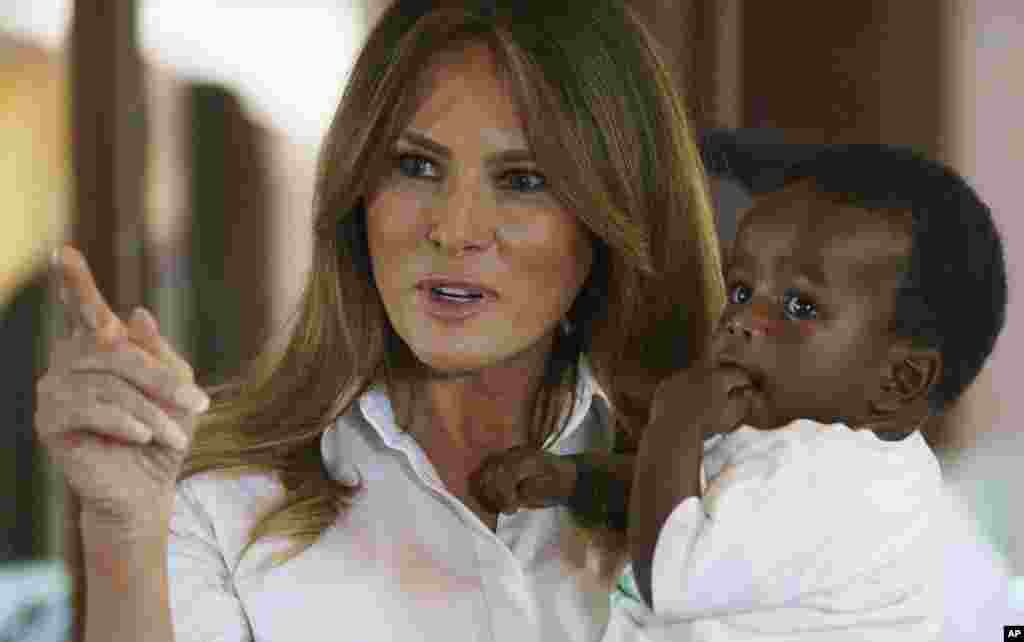 លោកស្រី​&nbsp;Melania&nbsp;Trump​&nbsp;បី​ទារក​មួយ&nbsp;ខណៈ​ពេល​លោកស្រីធ្វើ​ទស្សនកិច្ច​នៅ​មណ្ឌល​កុមារ​កំព្រា​&nbsp;Nest⁠&nbsp;Orphanage&nbsp;ក្នុង​ក្រុង​&nbsp;Limuru&nbsp;ប្រទេស​កេនយ៉ា&nbsp;កាល​ពី​​ថ្ងៃ​ទី០៥&nbsp;ខែ​តុលា​&nbsp;ឆ្នាំ​២០១៨។&nbsp;