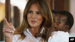 FILE - First lady Melania Trump holds a baby as she visits the Nest Orphanage in Limuru, Kenya, Oct. 5, 2018. 