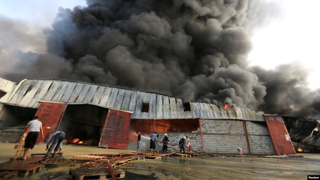 Petugas pemadam kebakaran memadamkan api di gudang Bantuan Pangan Dunia di Hodeida, Yemen, 32 Maret 2018. REUTERS/Abduljabbar