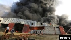 Petugas pemadam kebakaran memadamkan api di gudang Bantuan Pangan Dunia di Hodeida, Yemen, 32 Maret 2018. REUTERS/Abduljabbar