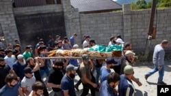 FILE - People carry the body of Zelimkhan Khangoshvili, a Chechen Georgian who fought against Russia in the Second Chechen War and had links with Georgian intelligence, during his funeral in Duisi village, Georgia, Aug. 29, 2019.