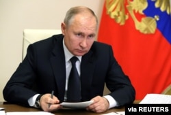 FILE - Russian President Vladimir Putin chairs a joint meeting of the country's State Council and the Council for Strategic Development and National Projects via a videoconference at Novo-Ogaryovo state residence, Dec. 23, 2020.