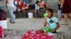 Una niña migrante venezolana lleva su comida al interior de un coliseo donde está instalado un campamento temporal, luego de huir de su país por operaciones militares, según la agencia colombiana de migración, en Arauquita, el 27 de marzo de 2021.