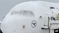 A snow covered aircraft is parked on the airfield at Berlin's Schoenefeld airport in Berlin, Germany, Monday, Dec. 20, 2010. Snow and freezing temperatures continued to cause holiday travel problems Monday for road, rail and air passengers all over Europe