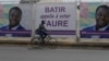 Un homme passe à vélo devant les affiches électorales du président sortant du Togo, Faure Gnassingbé, à Lomé, le 21 février 2020. (AP)
