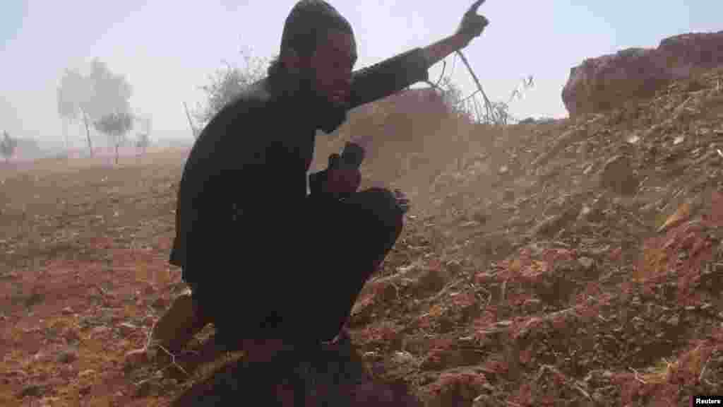A Free Syrian Army fighter reacts during what the FSA said were clashes with forces loyal to Syria's President al-Assad in the eastern Hama countryside, Oct. 14, 2013. 