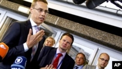 Finland's Foreign Minister Alexander Stubb, left, speaks with journalists as he arrives for a meeting of EU foreign ministers in Luxembourg. EU foreign ministers expanded sanctions against Syria as brutal repression of an uprising in the Middle Eastern co