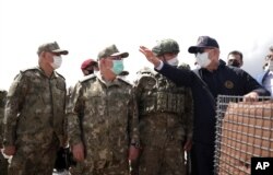 Turkey's Defense Minister Hulusi Akar, right, and top army commanders check the Turkey-Iran border in Van, eastern Turkey, Aug. 15, 2021.