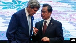 Ngoại trưởng John Kerry, trái, và Bộ trưởng Ngoại giao Trung Quốc Vương Nghị trao đổi sau khi chụp ảnh với những người đồng cấp tham dự Hội nghị thượng đỉnh các ngoại trưởng Đông Á ở Kuala Lumpur hôm 6/8.