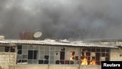 Una casa arde en Erbeen, cerca de Damasco, como resultado de lo que activistas dicen fue un ataque aéreo. El gobierno sirio podría estar utilizando también misiles Scud contra los rebeldes.