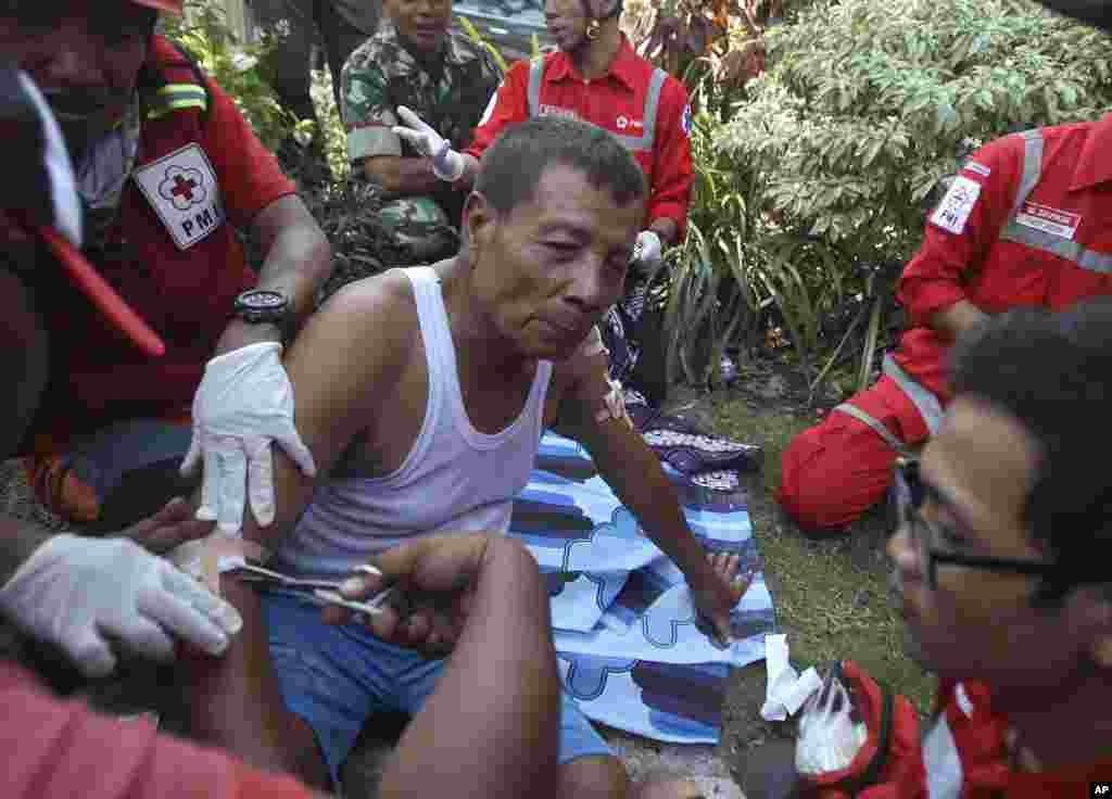 Petugas paramedis membantu seorang pria yang terluka dalam ledakan yang terjadi di sebuah gereja di Surabaya, Jawa Timur.