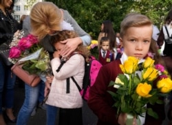 Seorang gadis di kelas satu menangis saat upacara menandai dimulainya kelas di sebuah sekolah di tengah pandemi COVID-19 di St. Petersburg, Rusia. (Foto: AP)