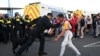 FILE - A police officer restrains a protester during a demonstration called by far-right activists in Weymouth, on the southwest coast of England where the Bibby Stockholm migrant accommodation barge is moored, on Aug. 4, 2024.