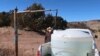 FILE -- Phillip Yazzie fills a water drum in the back of his pickup truck to be filled in Teesto, Ariz., on the Navajo Nation, on Feb. 11, 2021. 