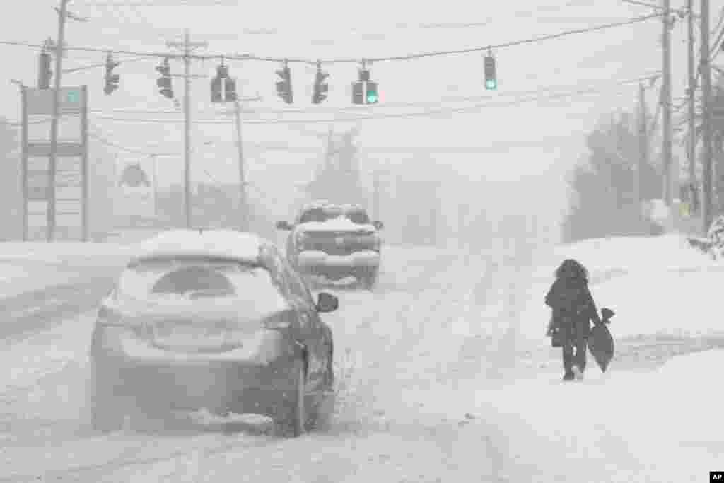 Caen fuertes nevadas mientras una persona camina por la Ruta 42 en Florence, Kentucky.