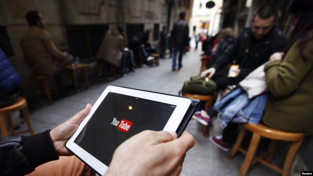 A man tries to get connected to YouTube with his tablet at a cafe in Istanbul, March 27, 2014.