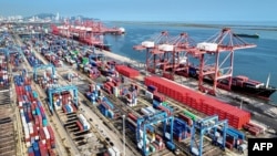 FILE - Shipping containers and gantry cranes are seen at a port in Lianyungang, in eastern China's Jiangsu province on Aug. 7, 2024.