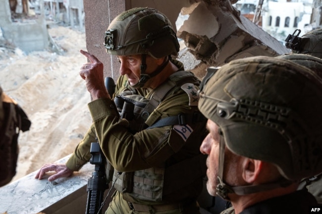 This photo released by the Israeli army on Oct. 17, 2024, shows the Chief of the General Staff Lieutenant-General Herzi Halevi, left, and the head of the Israeli Security Agency, Ronen Bar, visiting what the army says is the location where Hamas leader Yahya Sinwar was killed.