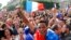 French soccer fans celebrate after France scored the first goal, as they watch the World Cup soccer match between France and Nigeria being shown live on a giant screen, in front of Paris City Hall, June 30, 2014.