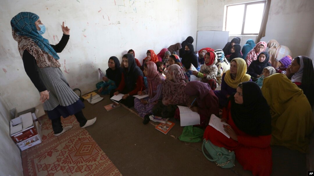 FILE - Afghan internally displaced school girls and women study at a class near their temporary homes on the outskirts of Kabul, Afghanistan, Oct. 30, 2017. 