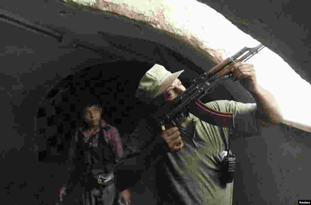 A Free Syrian Army fighter aims his weapon as he takes a defensive position in the old city of Aleppo, July 3, 2013. 