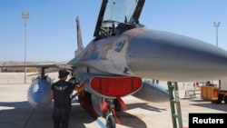 Seorang mekanik dari Angkatan Udara Israel memeriksa sebuah jet F-16 dalam latihan "Bendera Biru" yang melibatkan beberapa negara dan dilaksanakan di pangkalan udara Ovda, sebelah utara kota Eilat, Israel pada 24 Oktober 2021. (Foto: AFP/Jack Guez)