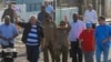 Cuban President Miguel Diaz-Canel, second left, and former President Raul Castro, center, wave as they arrive to a demonstration against the US embargo, in Havana, Dec. 20, 2024. 