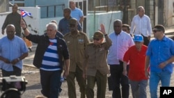 Cuban President Miguel Diaz-Canel, second left, and former President Raul Castro, center, wave as they arrive to a demonstration against the US embargo, in Havana, Dec. 20, 2024. 