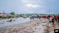 Residents are seen standing in the town of Katesh, in Tanzania, Dec 3, 2023 after landslides and flooding.