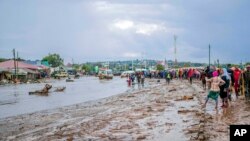 Resident are seen standing in the town of Katesh, in Tanzania, Sunday, Dec 3, 2023.